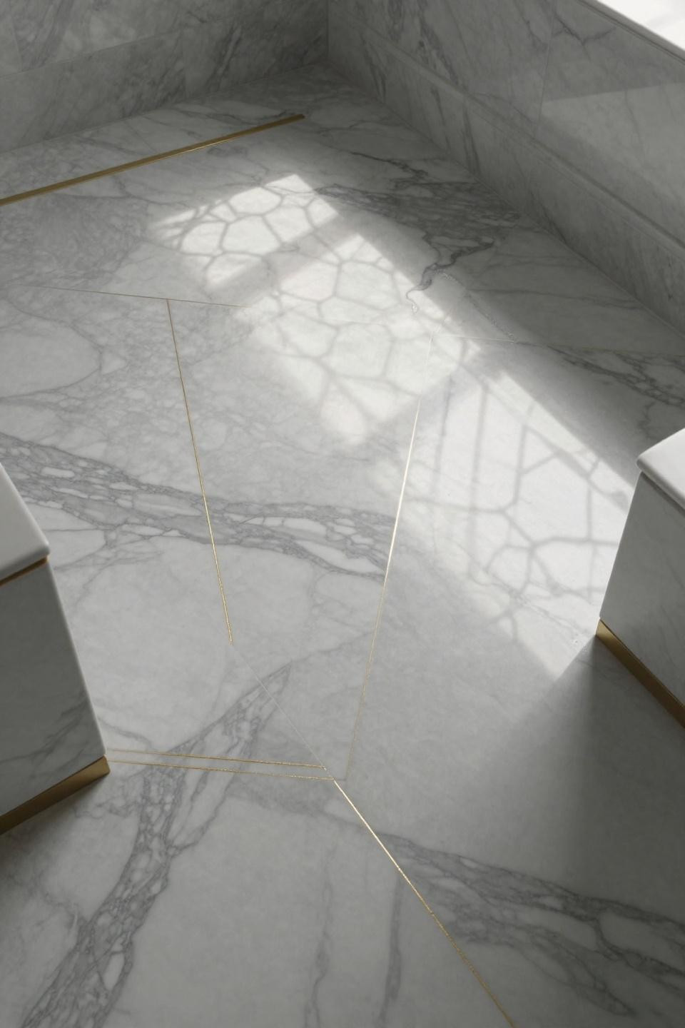 bathroom flooring ideas with hand laid carrara marble chevron pattern and 24 karat gold leaf running through veining
