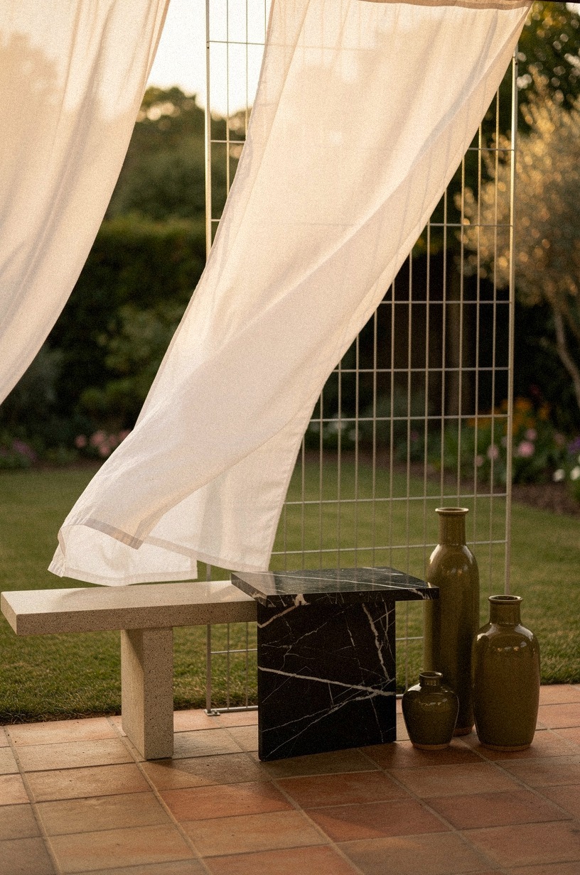 Drape a sheer outdoor curtain across a wire trellis divider