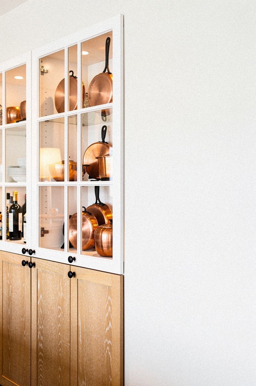 Display copper pans behind divided glass panes
