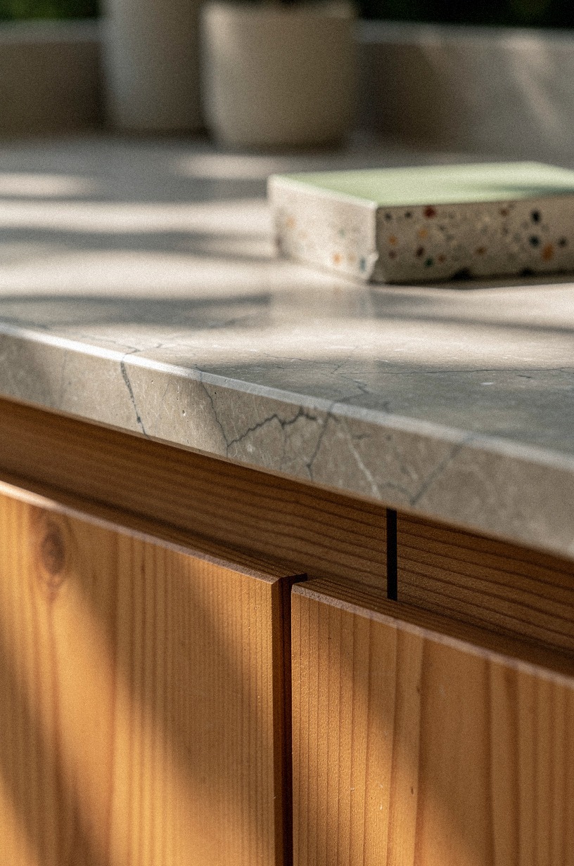 Compare marble-look sintered stone beside cedar cabinets