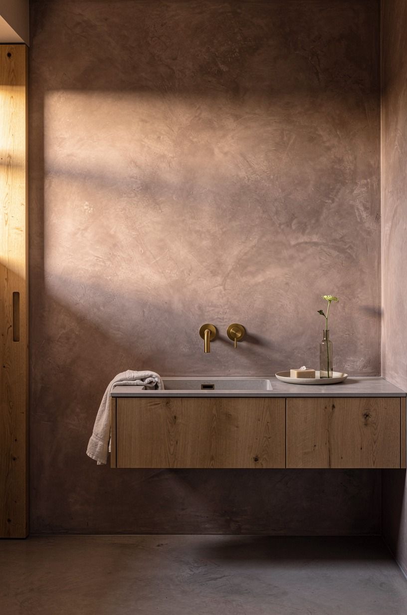 Warm gray microcement with brass fixtures