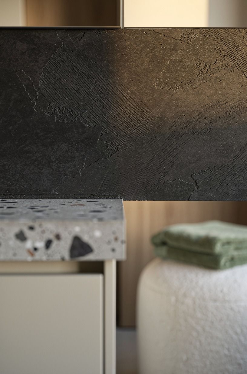 Trowel charcoal microcement behind the vanity