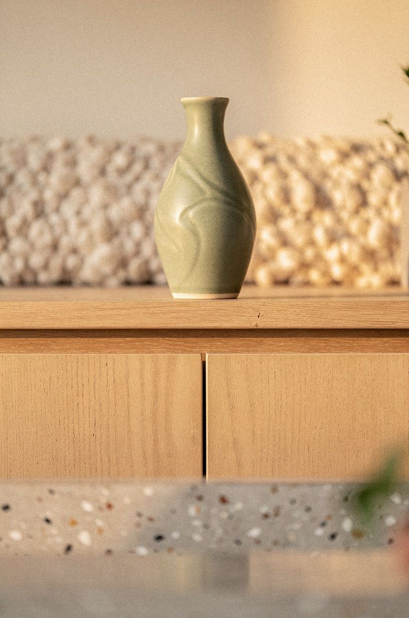 Anchor the gap with one sculptural vase