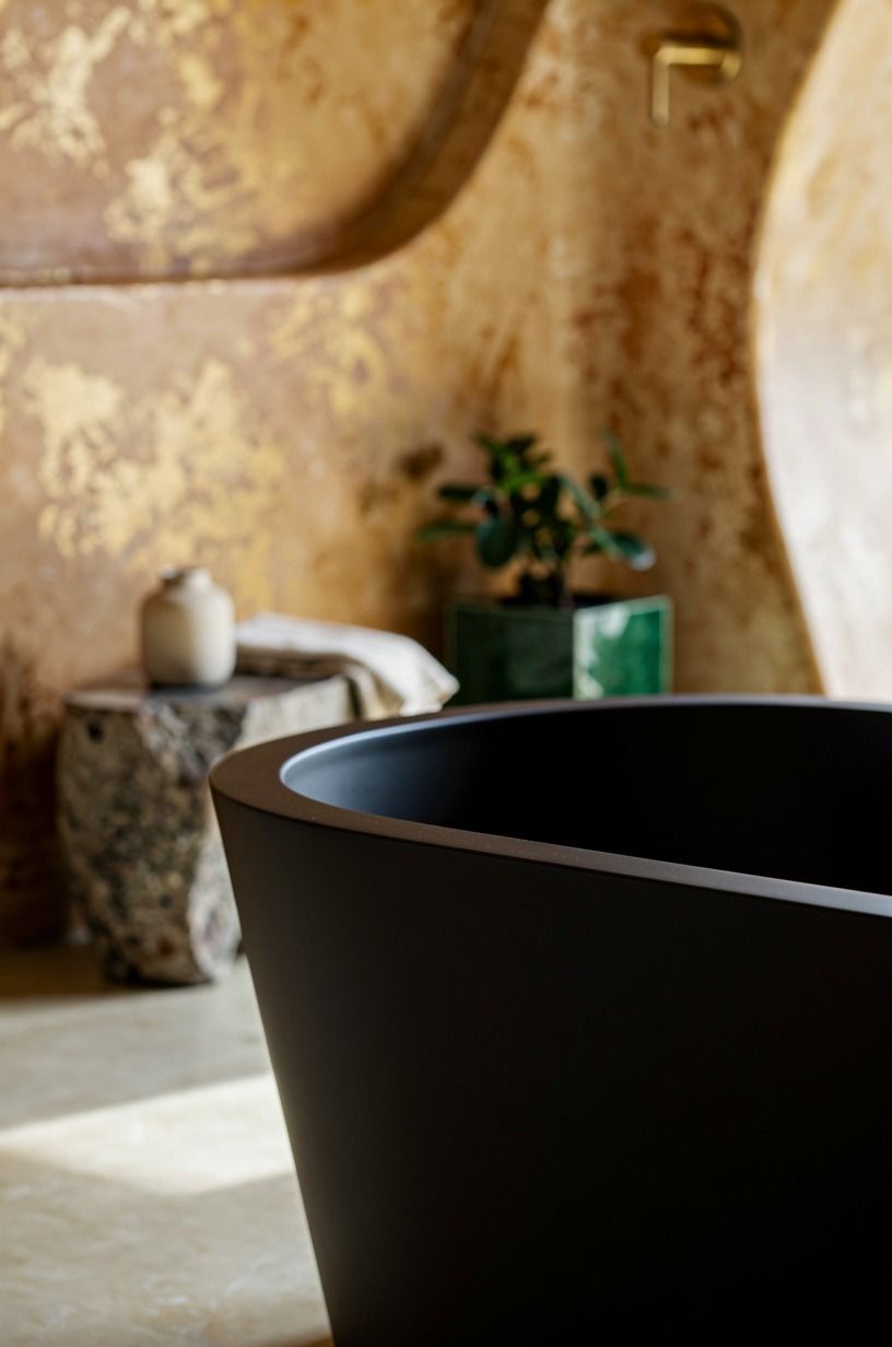 Contrast a black tub against warm plaster