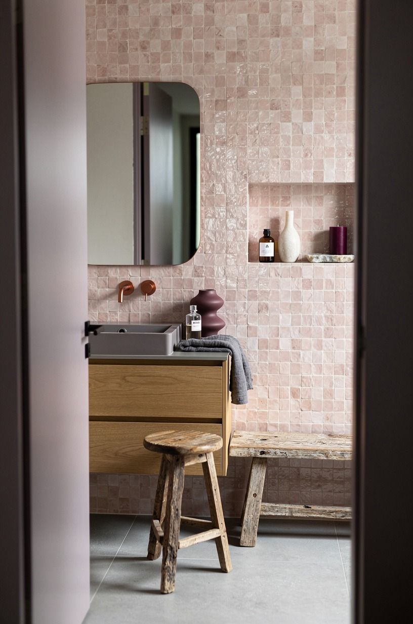 Layer blush zellige behind a warm oak vanity