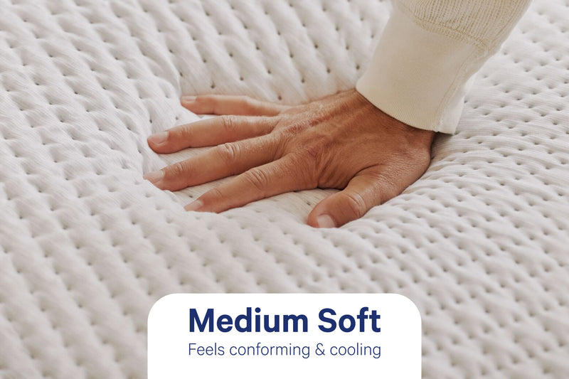 A hand pressing into the Casper Snow Max to show its medium-soft feel