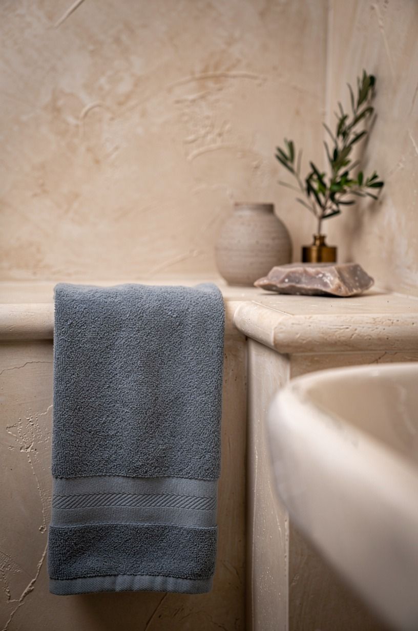 Mix a blue hand towel into an ivory bathroom tile scheme
