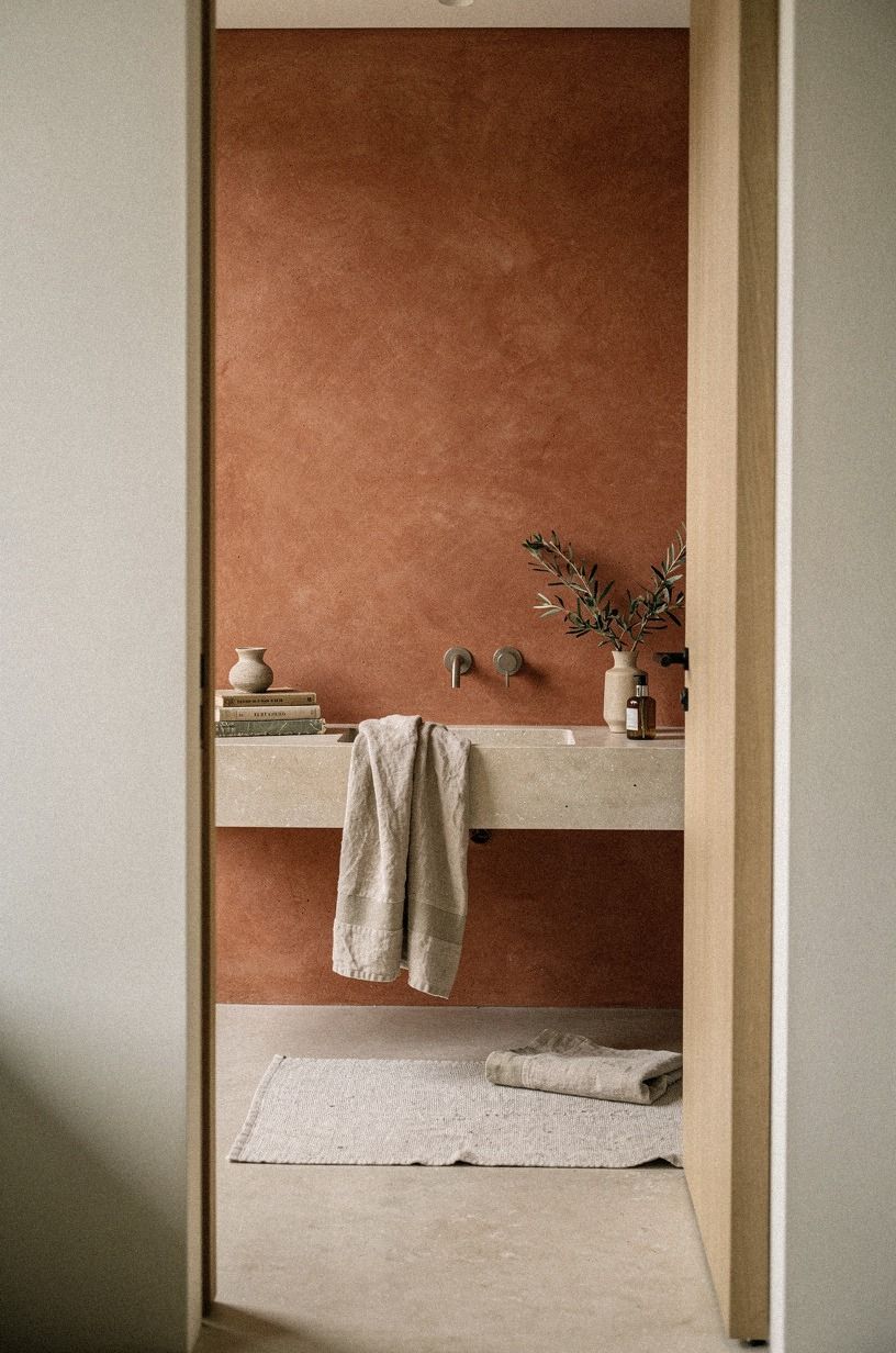 Mix clay bathroom warmth with pale stone